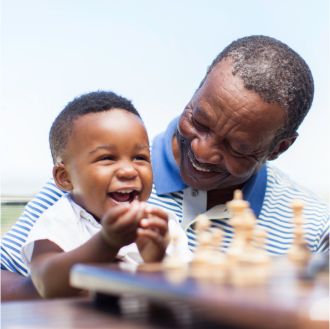 A grandfather playing with his grandson knowing his financial goals are protected.