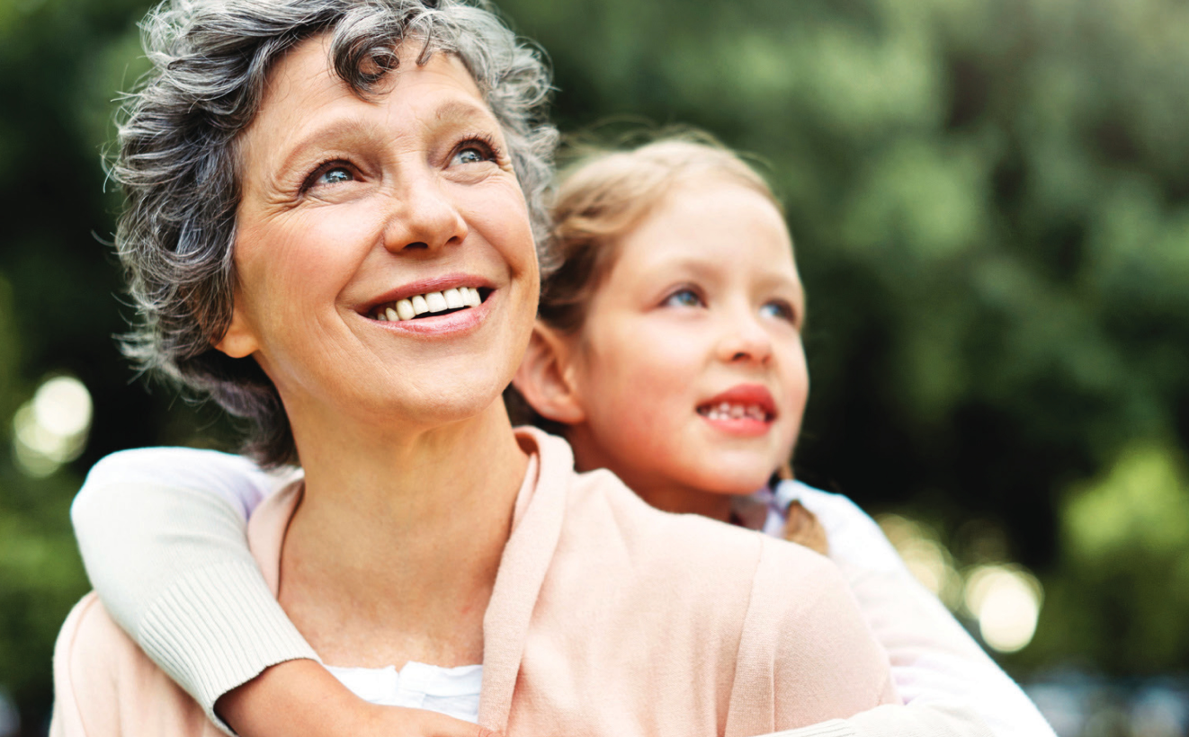A woman smiles with her granddaughter.