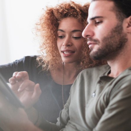 Man and woman using a tablet to read about Protective® Investors Benefit Advisory variable annuity product enhancements.