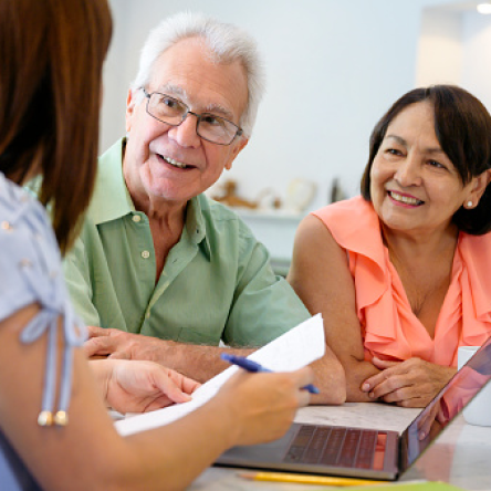 A financial professional meeting with a man and woman to discuss retirement spending.