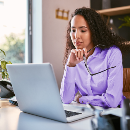 Financial professional reviewing accelerated underwriting process updates on her laptop.
