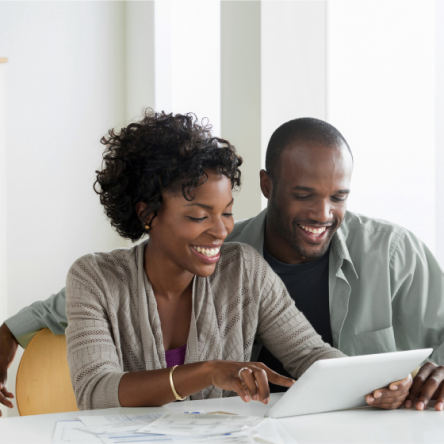A husband and wife using a tablet to review information about indexed universal life insurance.