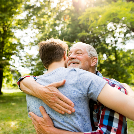 A grandfather embracing his teenage grandson, knowing he has a stronger legacy with Protective Series Estate Maximizer whole life insurance.