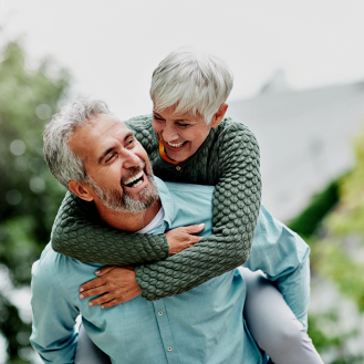 A retired couple smiling and feeling carefree.  