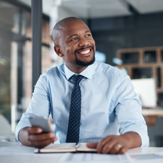Executive smiling after reading a message on their smartphone.