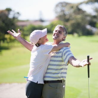 Couple who recently purchased a registered index-linked annuities to help limit loss and support growth, celebrate a great golf putt.