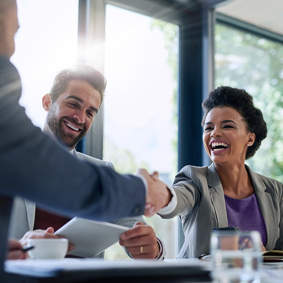 A couple meeting with a financial professional and shaking hands.