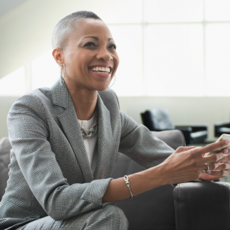 An executive reading exciting news on their smartphone.