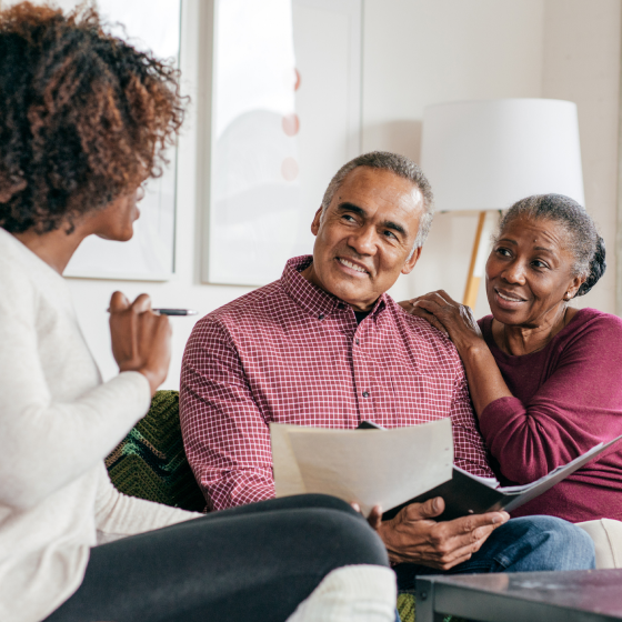 A financial professional using a tablet to show a husband and wife information about Protective Survivor UL.