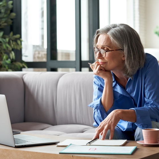 A woman using her computer to review information about whole life insurance