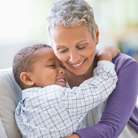 A woman embraces her grandchild.