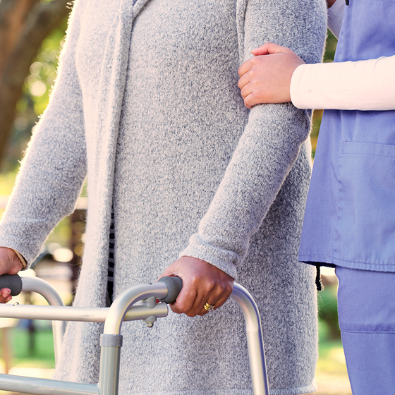 A woman uses a walker.
