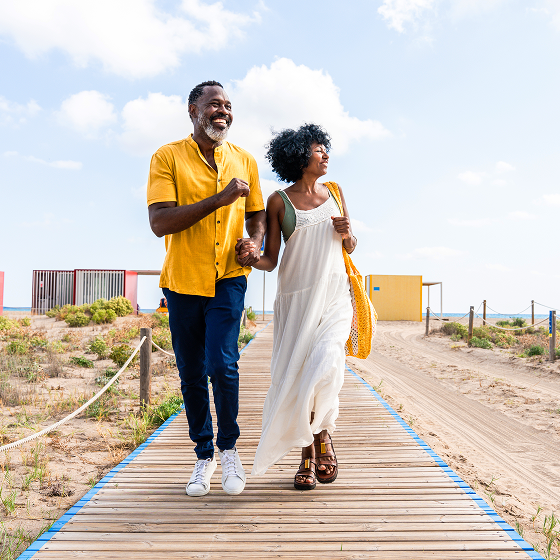 A couple walks from the beach, secure in their retirement with Protective Aspirations variable annuity.