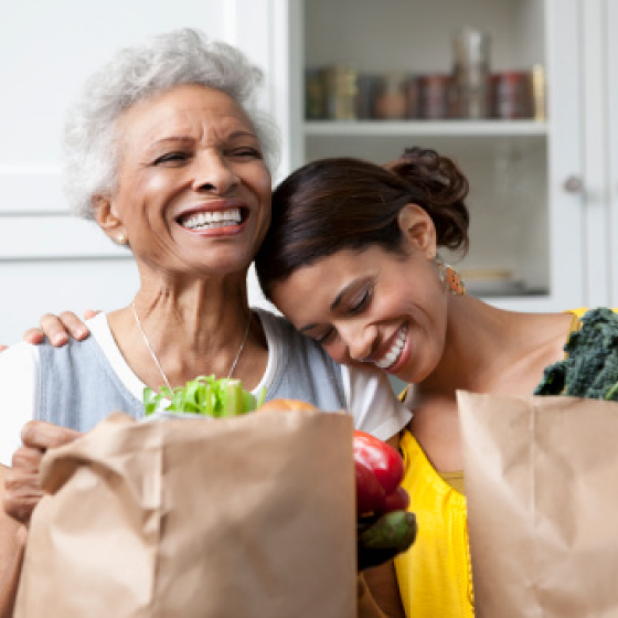 A mother smiling with her adult daughter.
