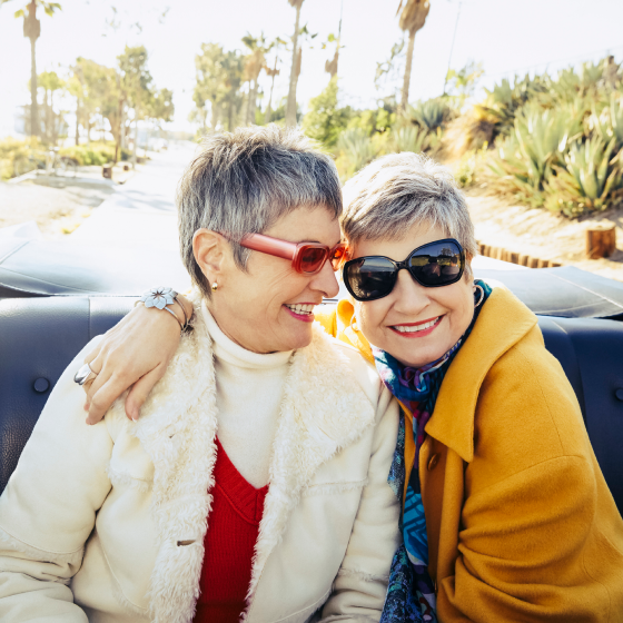 Two women riding in a car together and smiling, knowing they are protected with Protective Survivor UL.