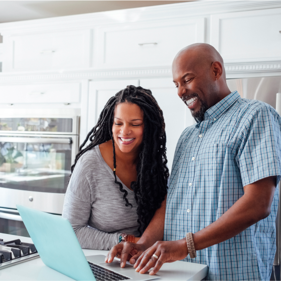 Couple review the Riders and Endorsements Guide on a laptop in their kitchen