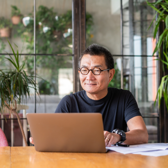 Man sitting with laptop reviewing Protective ProPayer Income Annuity key product specs.