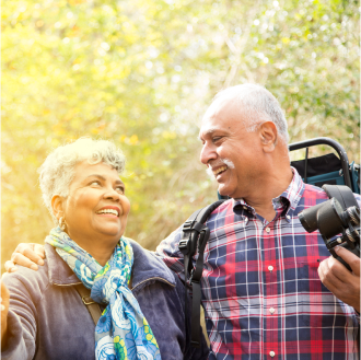 A retired couple smiling on a hike knowing their financial goals are protected.