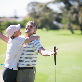 Couple who recently purchased a registered index-linked annuity to help limit loss and support growth, celebrate a great golf putt. 