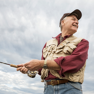 A man smiling while fishing, knowing he is protected with whole life insurance.