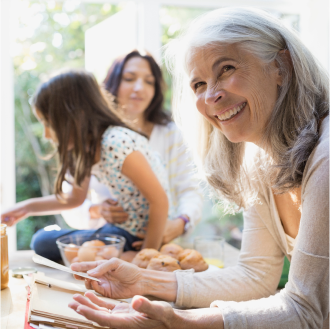 Grandmother, who represents a potential Protective Secure Saver fixed annuity client, reviews recipe while cooking with daughter and granddaughter.