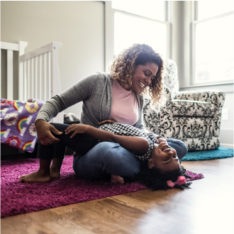 A woman playing with her young daughter, knowing her family is protected with Protective Custom Choice universal life insurance.