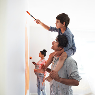 A couple and their young son painting a baby's room.