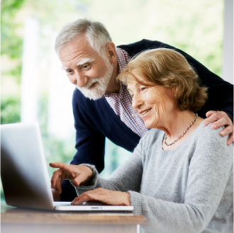 Couple researching guaranteed retirement income options on computer.