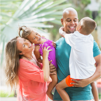 Couple laughing with their kids while knowing their family is protected by life insurance.